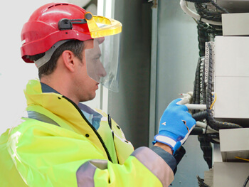 Worker with safety hat and gloves on working on equipment